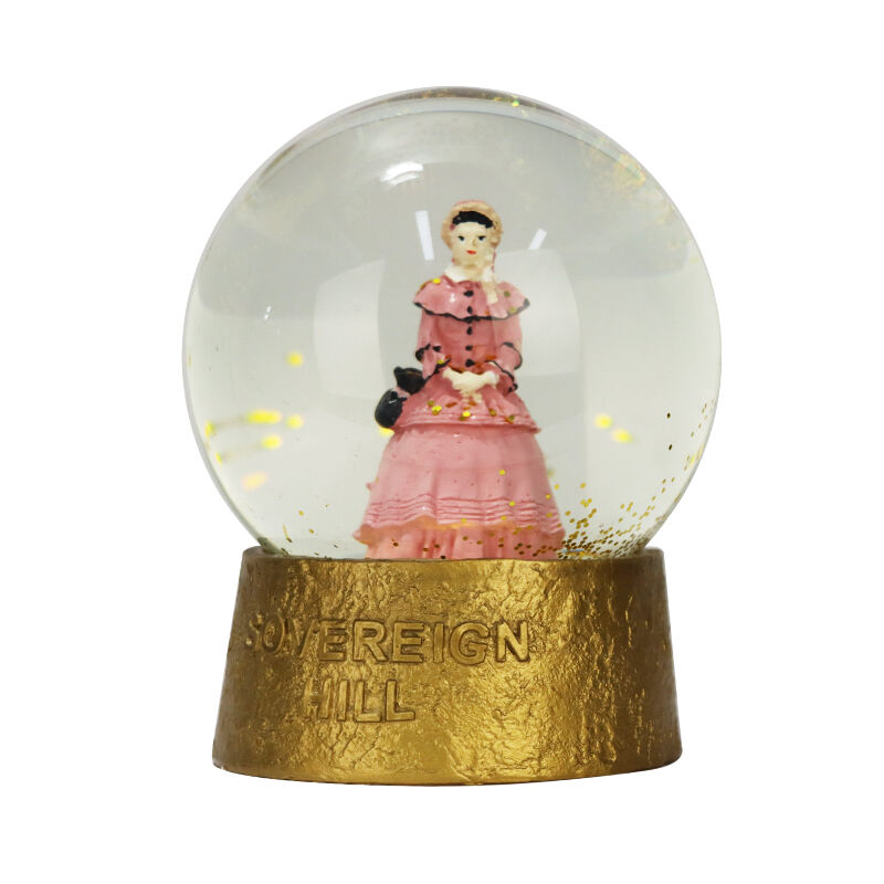 Vintana damica v rožnati obleki v snežni krogli - eleganten kolekcijski predmet