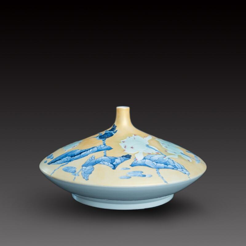 Une bouteille soucoupe volante en porcelaine bleue et blanche à fond doré, avec un lotus s'élevant.