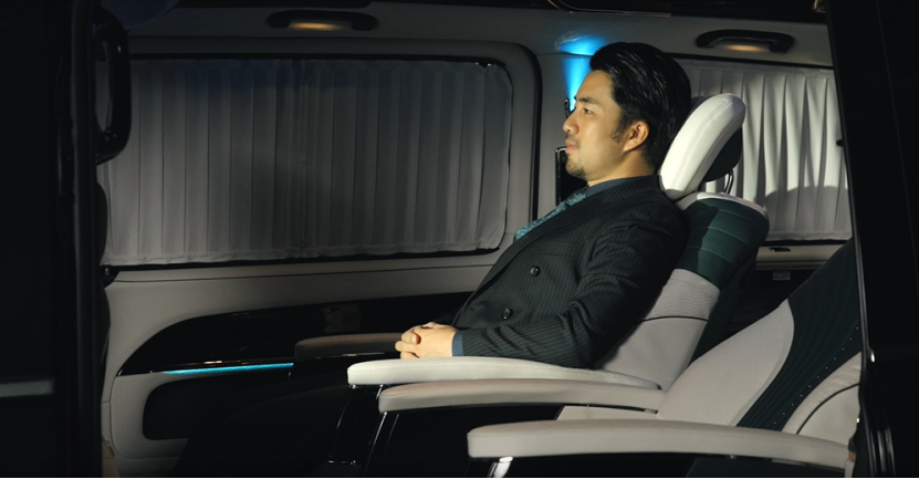Businessman enjoys a comfortable journey with smart voice assistant in a luxury vehicle.