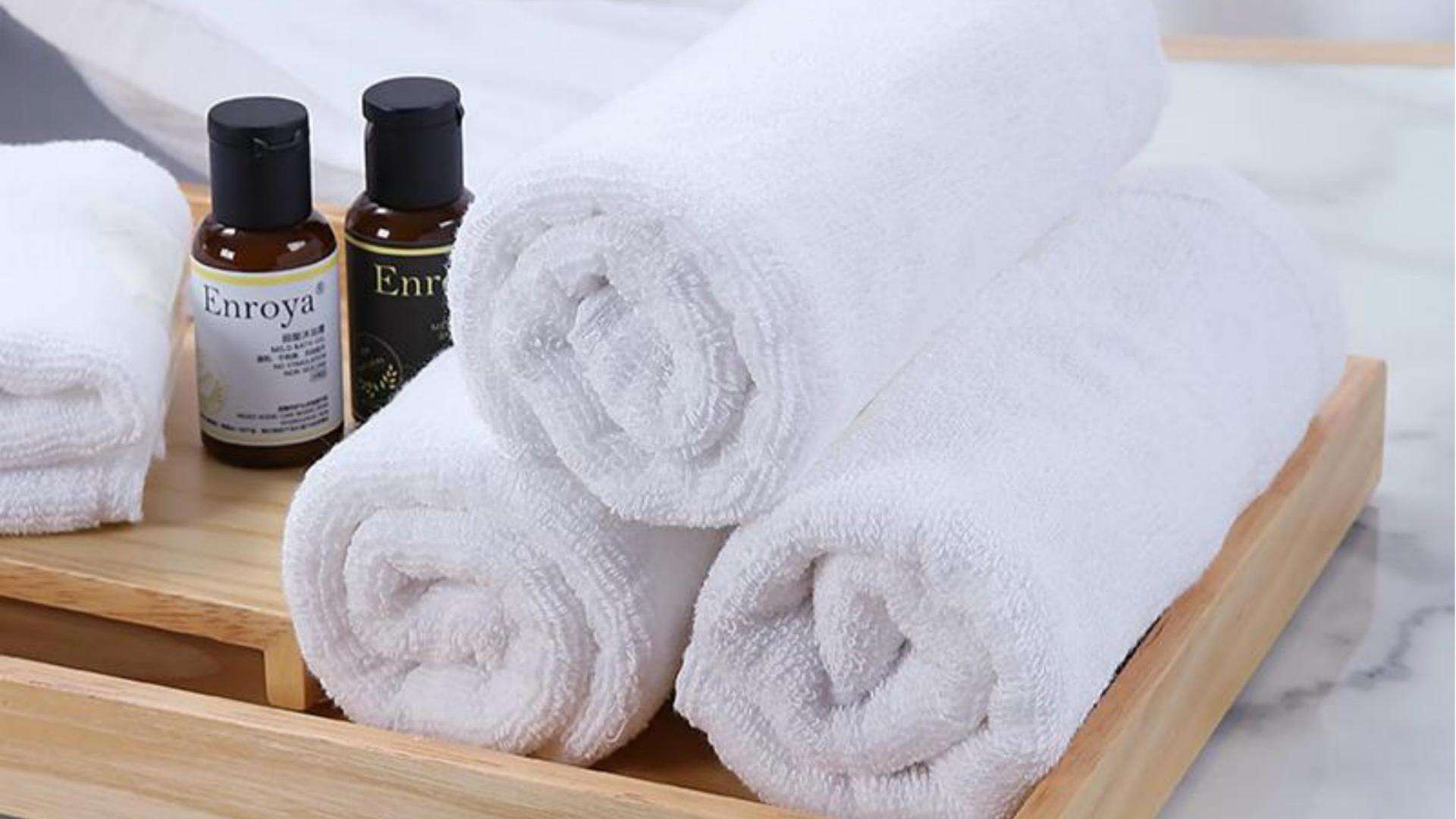 Luxurious spa-style presentation featuring rolled Taitang towels and amenity bottles on a wooden tray, ready for guest arrival..jpg