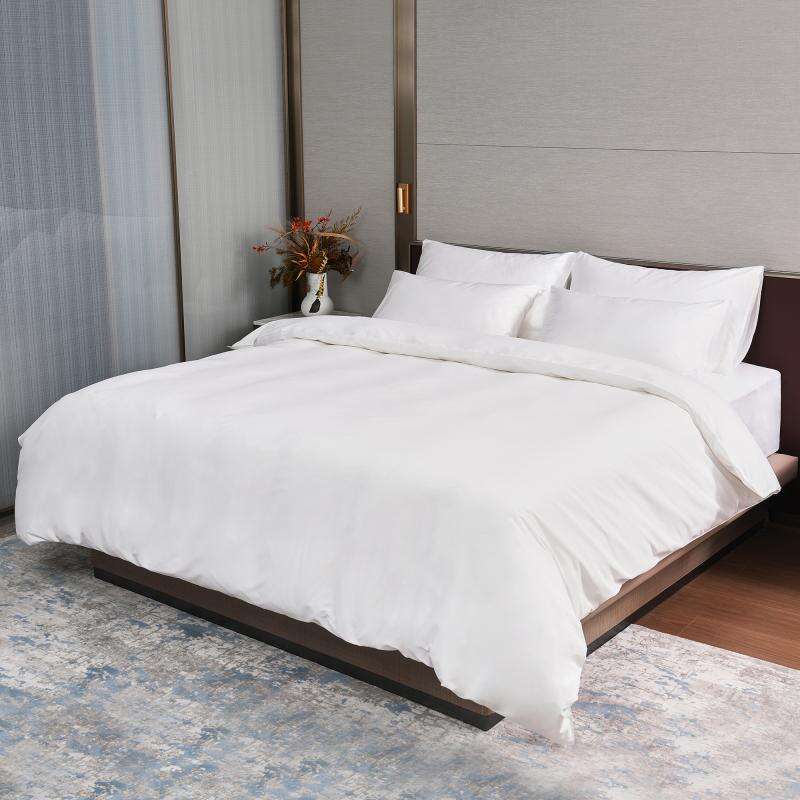 A fully dressed luxury hotel king bed featuring Taitang crisp white commercial bedding sheets and duvet cover.jpg