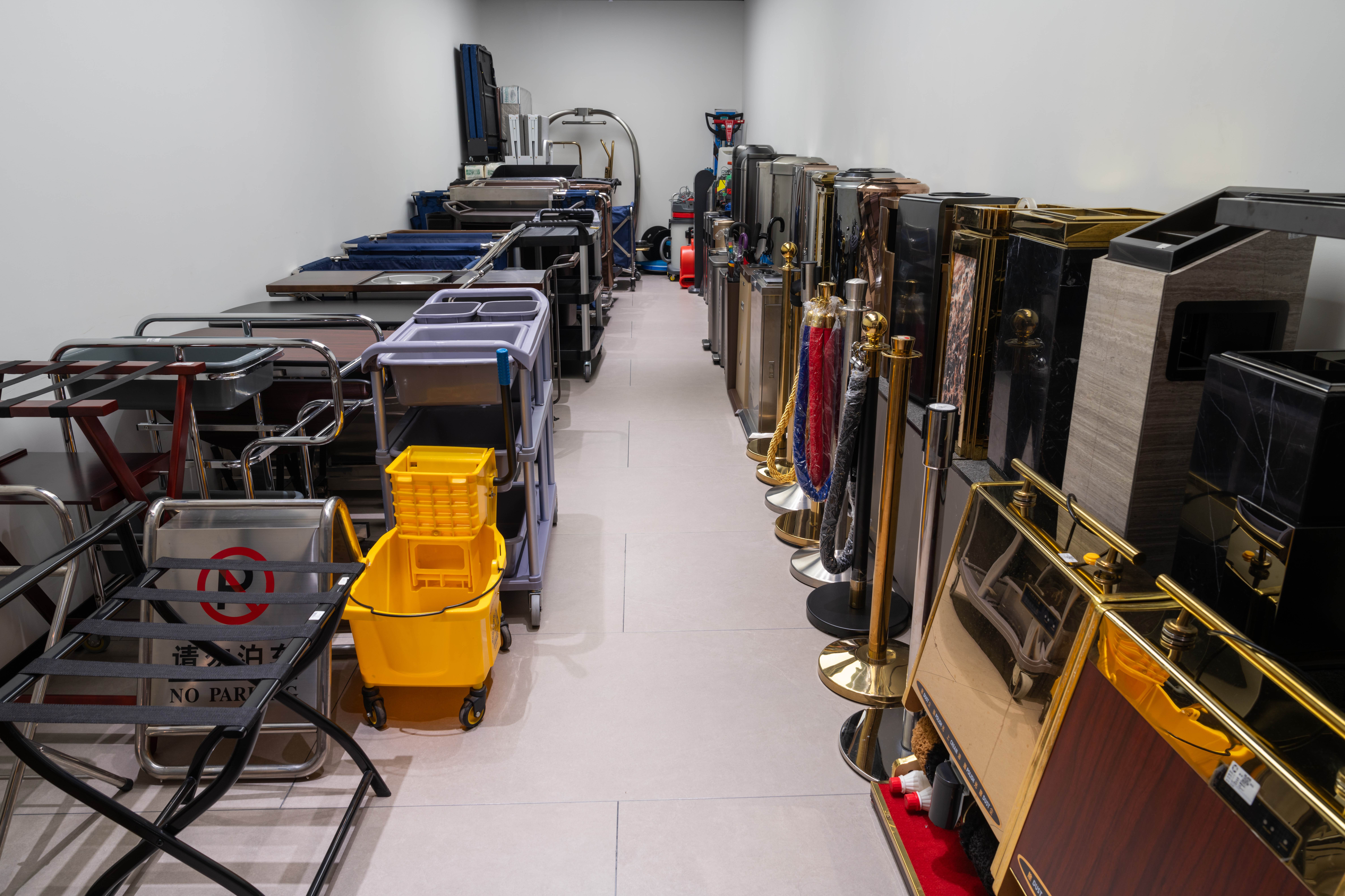 A comprehensive collection of Taitang public area and cleaning equipment, featuring professional luggage trolleys, housekeeping carts, crowd control stanchions, and lobby signage stands in a well-organized showroom, designed for high-traffic hotel operations.