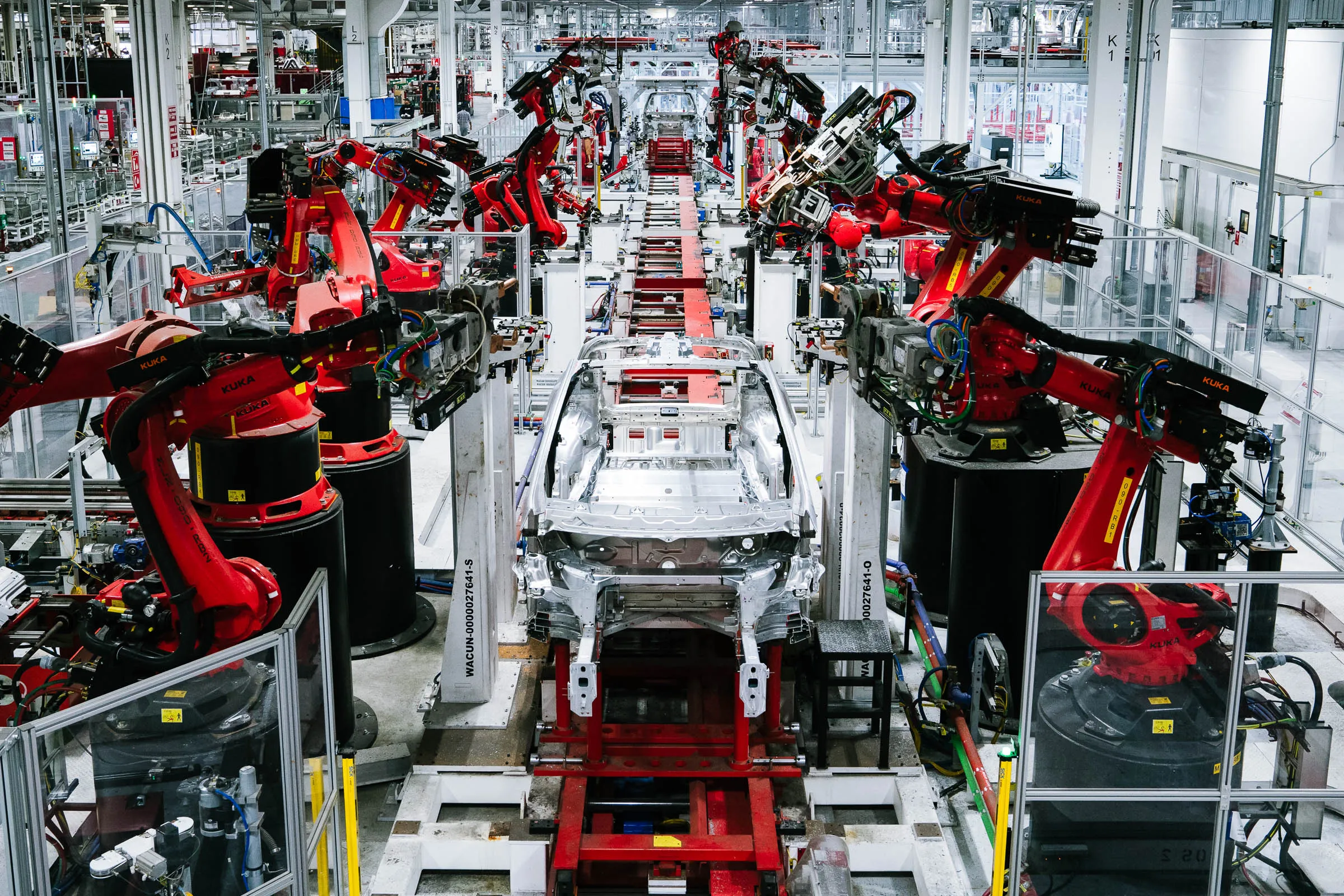 Robotic arms welding and painting cars on an automotive assembly line
