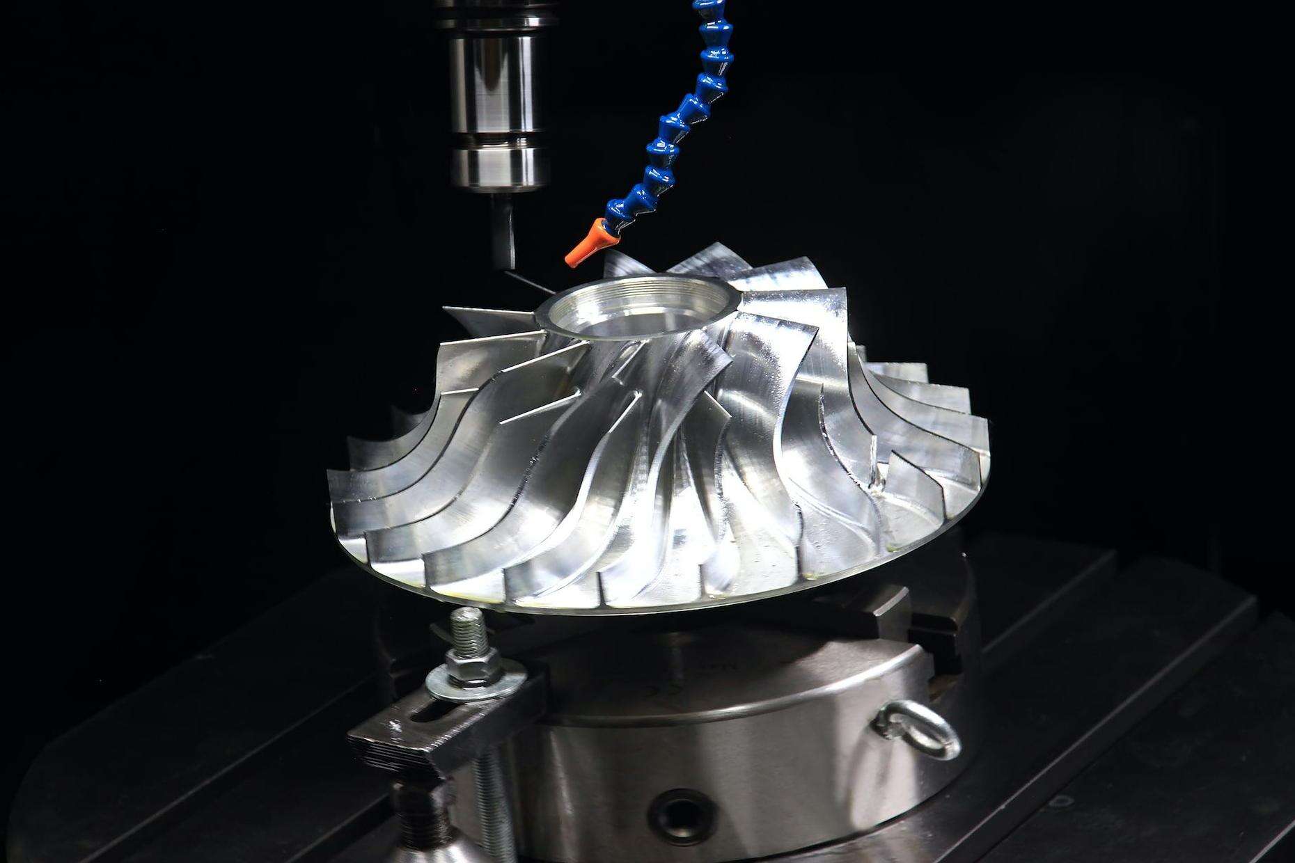 5-axis CNC machining aerospace component with rotational axis indicators showing reduced alignment errors