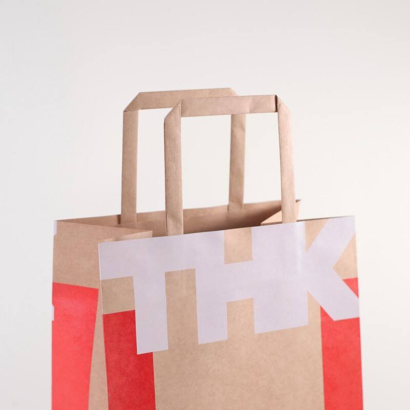 Op maat gemaakte logo-eco-vriendelijke, reliëfgedrukte kraftpapiergeschenkzak voor verpakking van voedsel, schoenen en sokken, geschikt voor winkelen