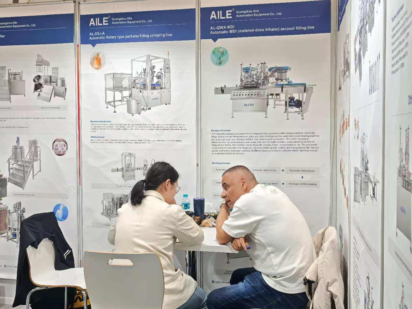 AILE team talking with a client at the booth