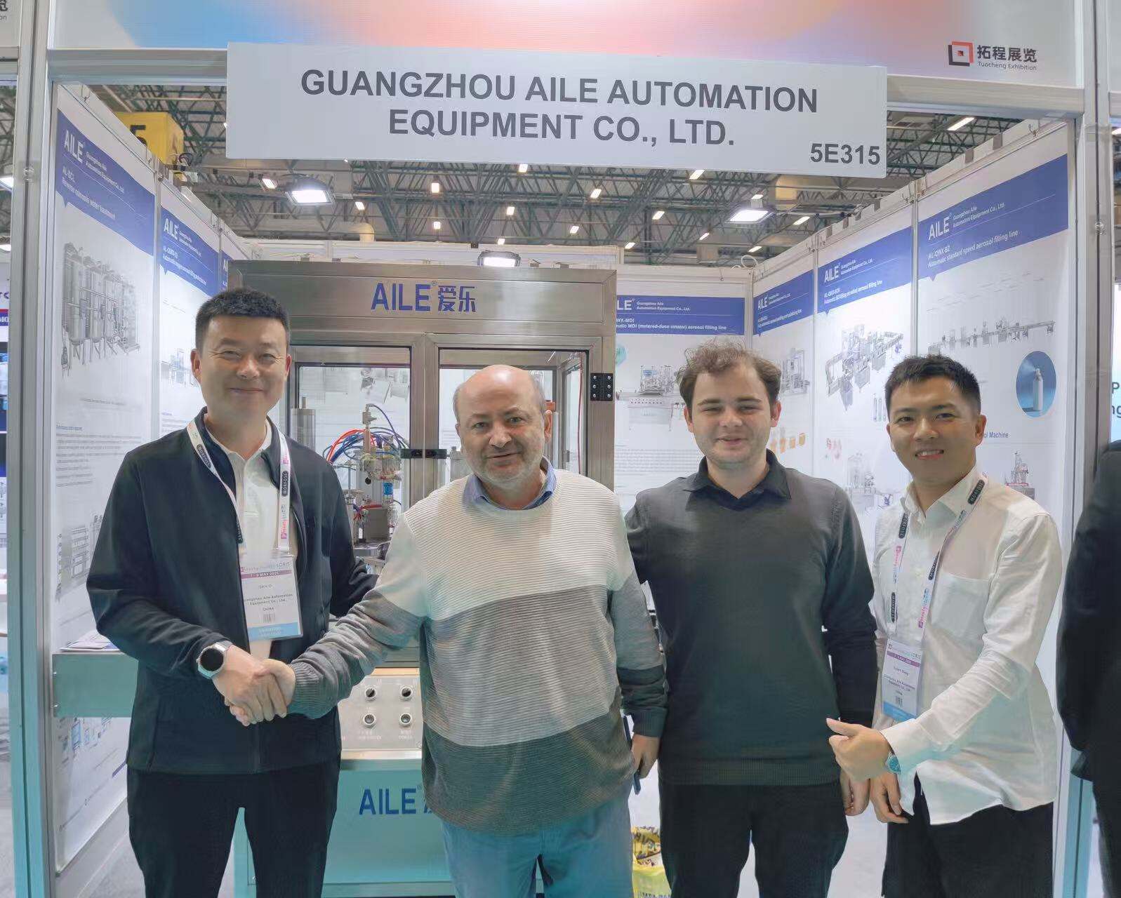 AILE team posing with an existing client at the booth