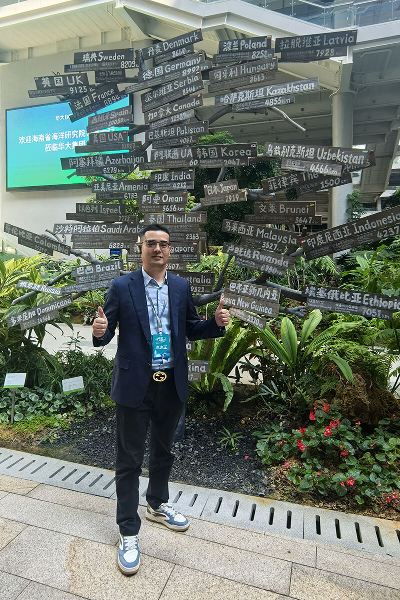 Dawson (Xiamen University EMBA participant) posing at BGI Group global partnership installation with country names.jpg