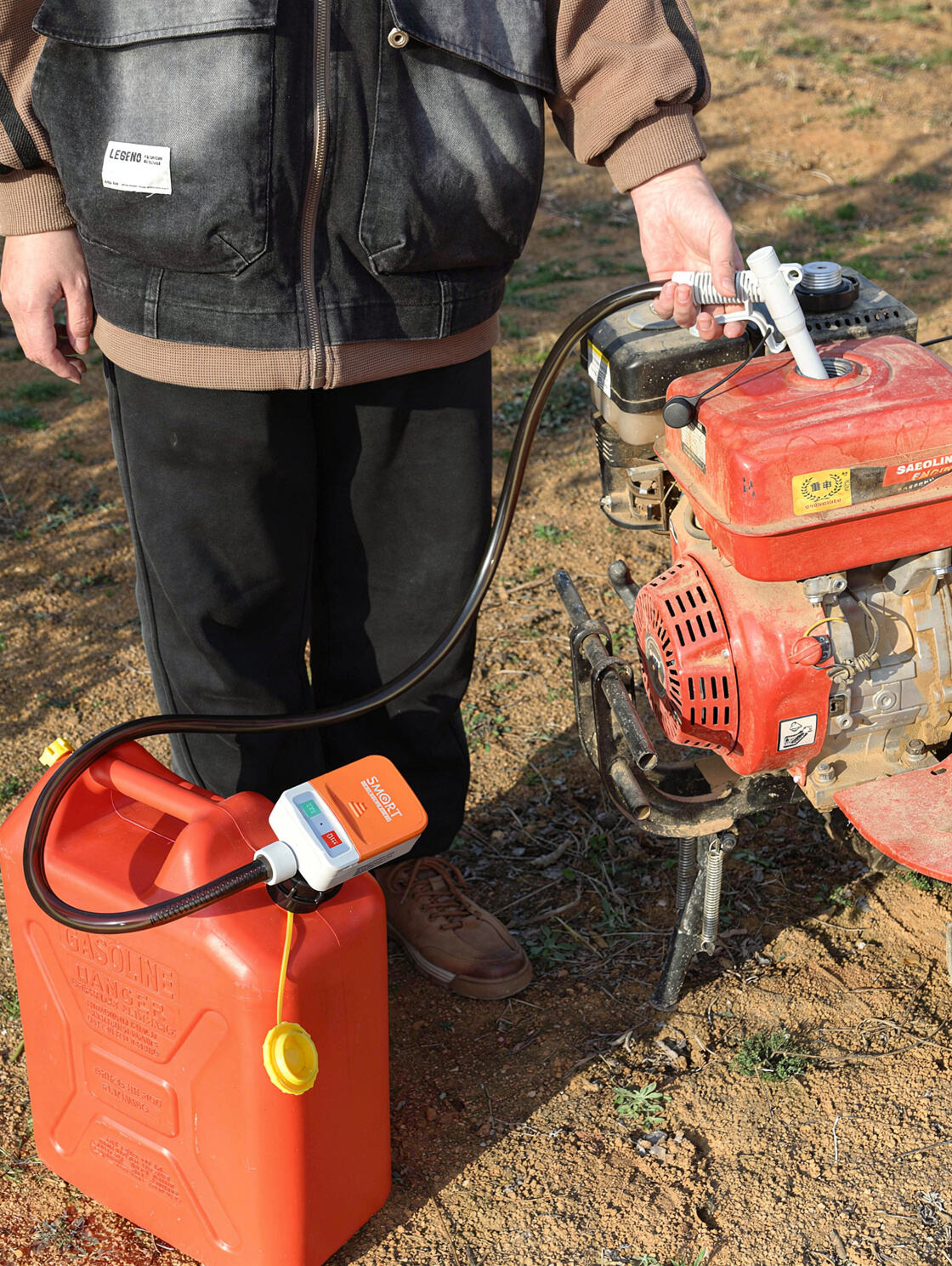 Portable fuel transfer pump with overflow protection auto-stop sensor being used to refuel generator in field