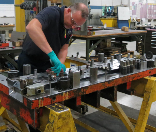 precision maintenance inspection of stamping die components on workshop bench