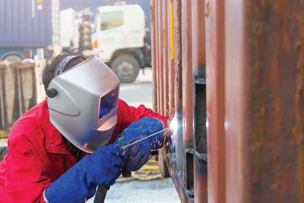 welder using full eye protection in a controlled work area