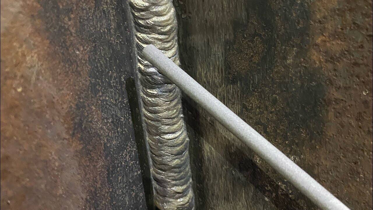 welder performing vertical up stick welding on a steel joint