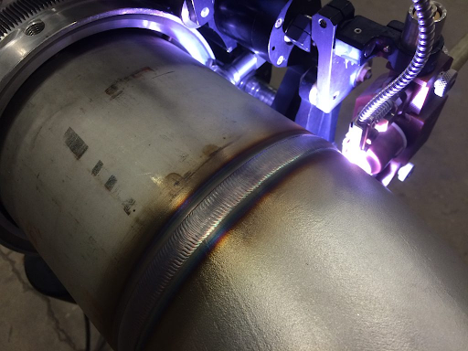 orbital tig welding head moving around a fixed tube joint
