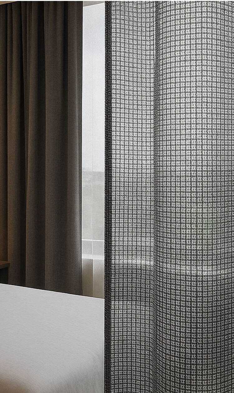 White sheer curtains tied back on a window, showcasing transparency and flowing drape in a minimal interior.