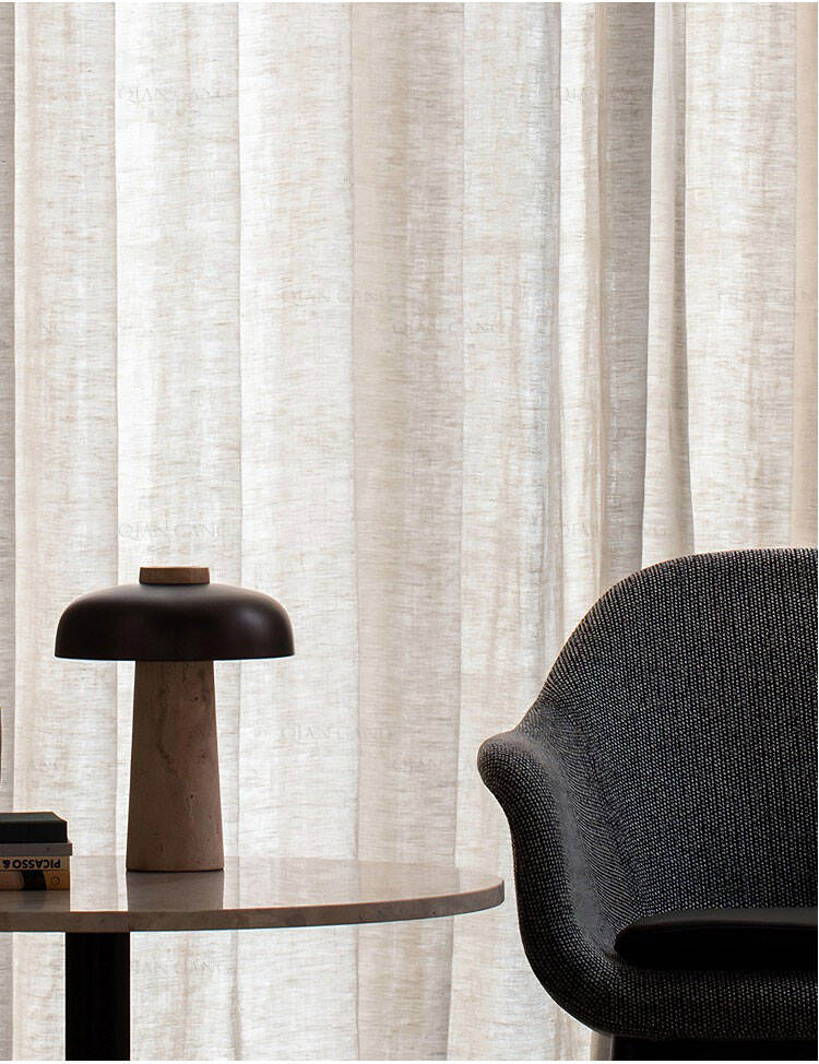 Beige yarn-dyed sheer curtain fabric styled with modern furniture, creating a warm, elegant atmosphere in living space.