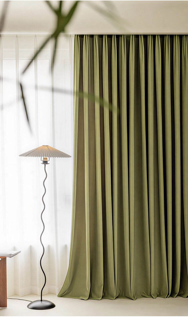 Olive green curtains with floor lamp, highlighting rich color depth and elegant hanging folds.