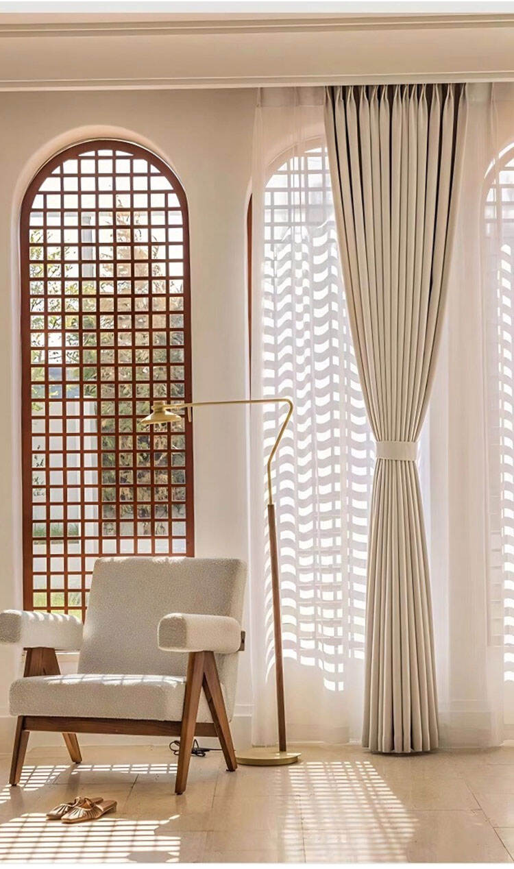 Bright living room with beige linen-look oxford curtains tied back over sheer drapes, creating soft sunlight and a calm ambiance.