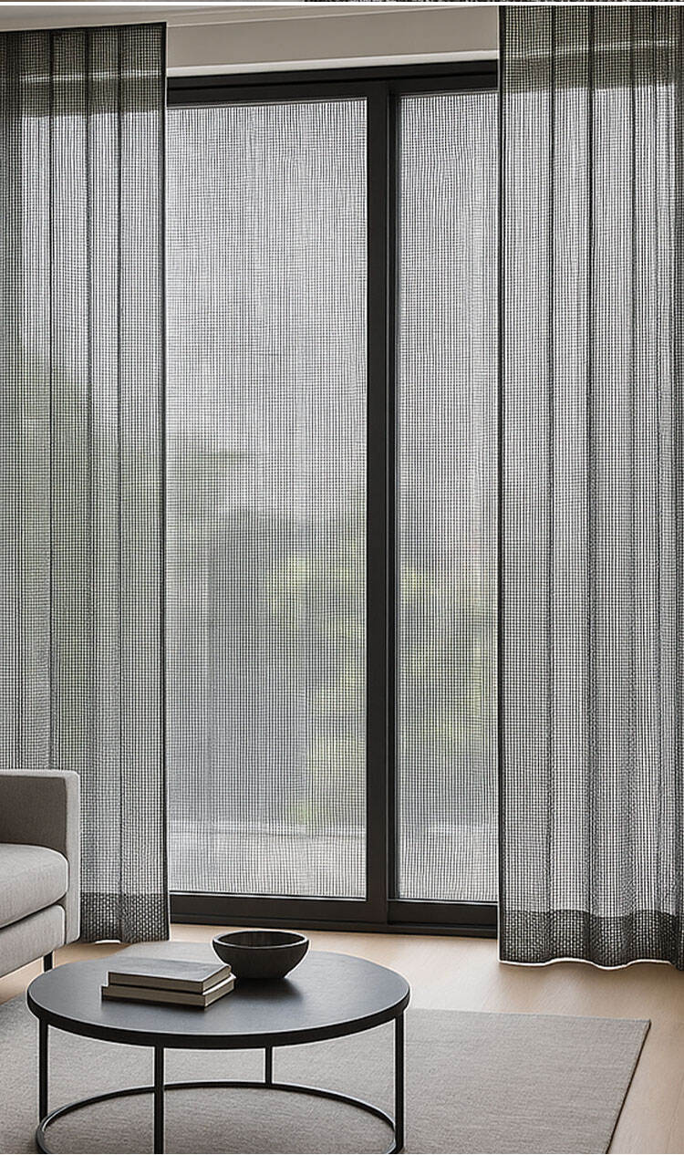 Minimal living space with white sheer curtains, gentle daylight diffusion, floor lamp, and warm wood flooring.