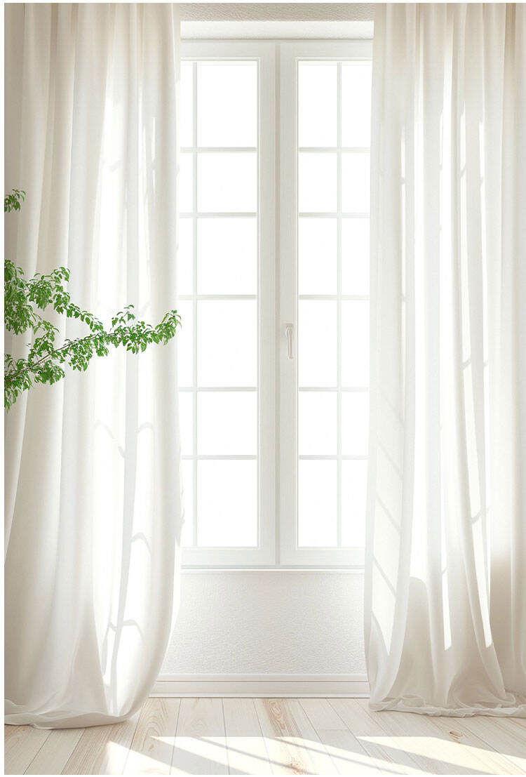 Sheer white curtains on a tall window, gently filtering sunlight to keep the space bright while maintaining privacy.