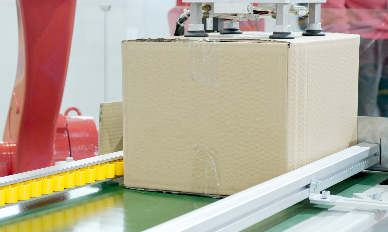 Die automatische Produktionslinie verwendet ein Karton-Sauggreifgerät, um fertige Produktkartons in das Lager zu transportieren.