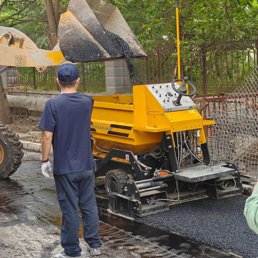 Demonstration of asphalt paving by a small asphalt paver and road roller